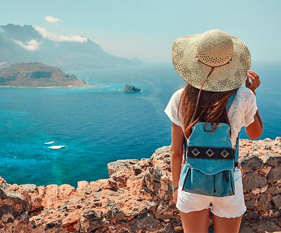 Lady on coastal walk looking over sea and mountains